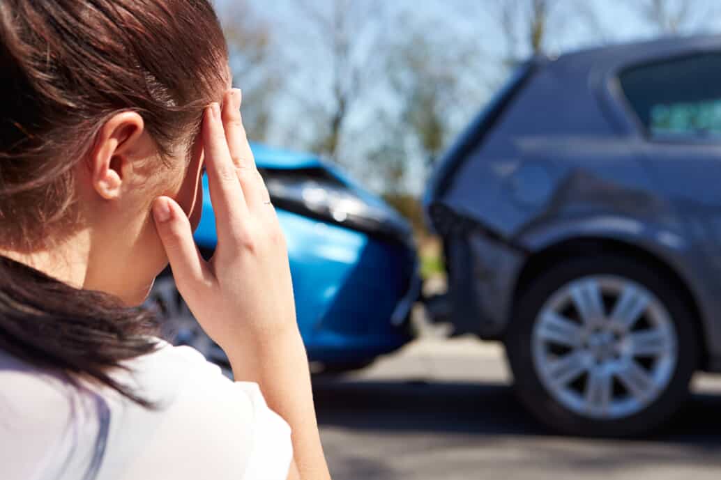 Woman with hand on head after a car accident